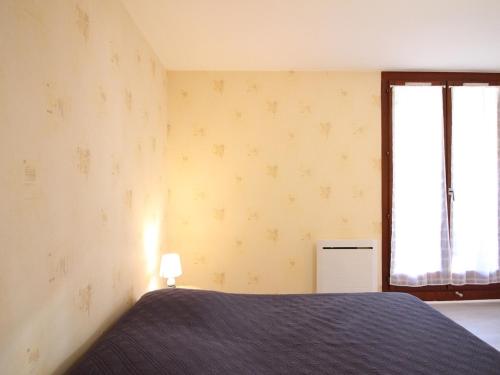 une chambre avec un lit et une fenêtre dans l'établissement Appartement F2 bis de 45m² avec balcon, parking et tout confort au Mont-Dore - FR-1-415-116, à Le Mont-Dore