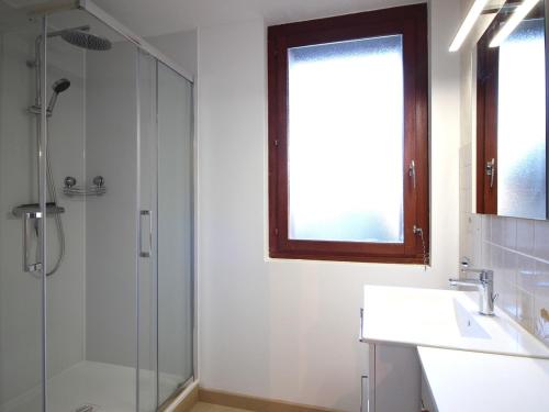 une salle de bain avec une douche, un lavabo et un miroir dans l'établissement Appartement F2 bis de 45m² avec balcon, parking et tout confort au Mont-Dore - FR-1-415-116, à Le Mont-Dore