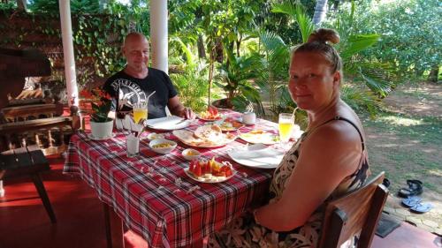 a man and a woman sitting at a table with food at Turtle Island Cabana in Tangalle