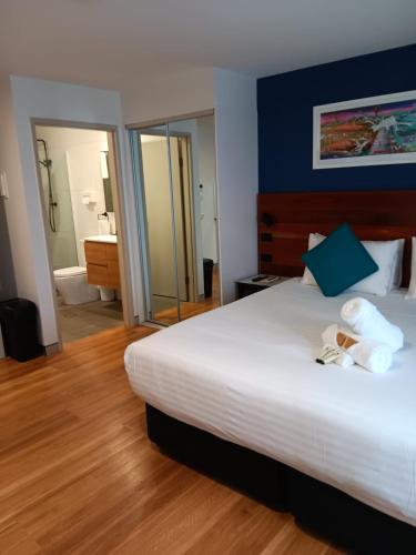 a bedroom with a large white bed and a bathroom at Hunter Studios - Maitland in Maitland