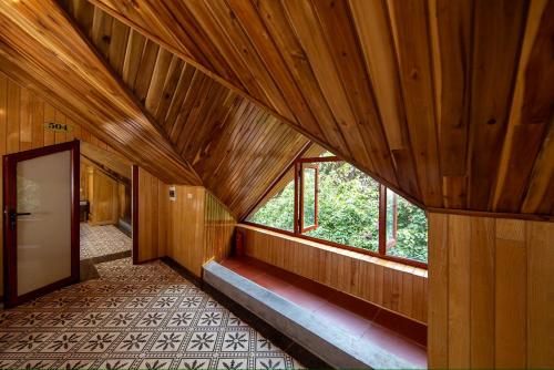 a hallway of a wooden building with a large window at Hang Mua Ecolodge in Ninh Binh
