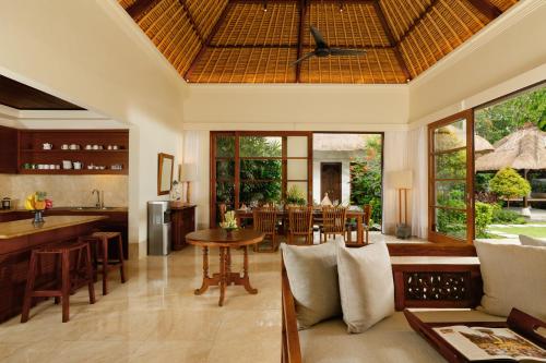 an open kitchen and living room with a table and chairs at Jimbaran Beach Villas by Nakula in Jimbaran