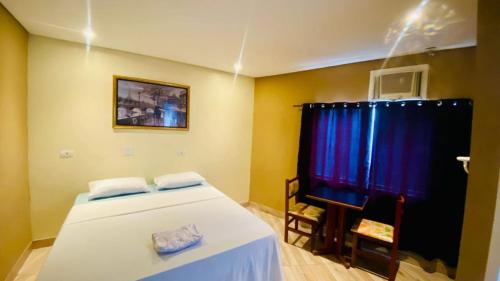 a bedroom with a bed and a table and a chair at Hotel Ibirapuera in Sao Paulo