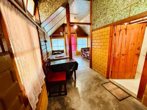 a room with a table and a red chair at Cozyo Stays Boutique Home Jowai in Jowai