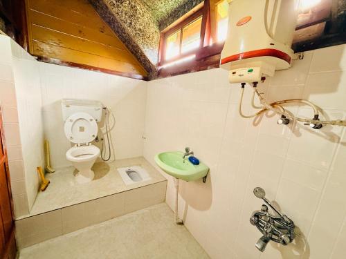 a small bathroom with a toilet and a sink at Cozyo Stays Boutique Home Jowai in Jowai