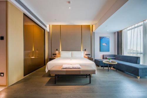 a hotel room with a bed and a couch at Atour Hotel Dongguan Humen Avenue in Dongguan