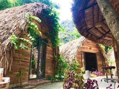 a house with a thatched roof at Hang Mua Ecolodge in Ninh Binh