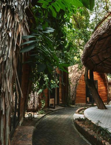 a path in front of a building with trees at Hang Mua Ecolodge in Ninh Binh