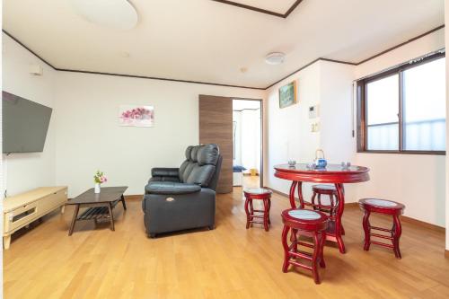 a living room with a table and a chair at Uhome Haneda Apartment in Tokyo