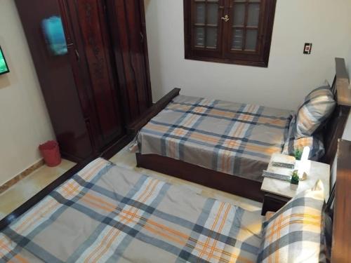 亚历山大Modern Entire studio, few steps from the sea with garden view Balcony and Free Wi Fi in Alexandria的一间卧室配有两张床、一张沙发和一个橱柜