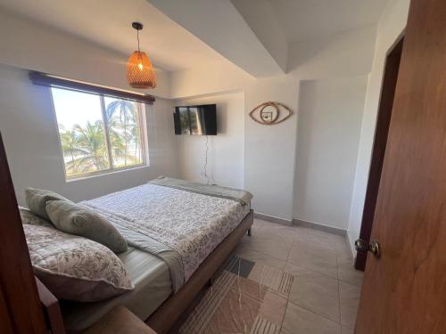 a bedroom with a bed and a window at Manolo IV,playa y relajacion in Tucacas