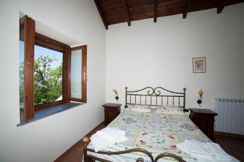 a bedroom with a large bed with a window at Agriturismo La Molara in Sessa Aurunca