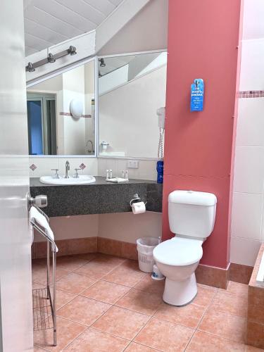a bathroom with a toilet and a sink at Shelly Beach Resort in Port Macquarie