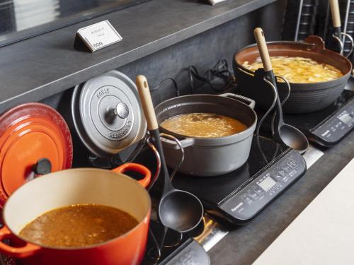 a stove top with pots and pans on it at Richmond Hotel Obihiro Ekimae in Obihiro
