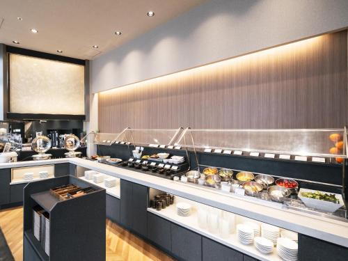 a restaurant kitchen with a counter with food at Richmond Hotel Obihiro Ekimae in Obihiro