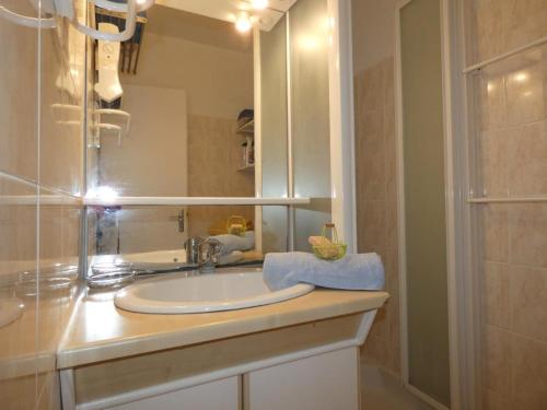 La salle de bains est pourvue d'un lavabo avec miroir et d'une douche. dans l'établissement Appartement T2 à Notre-Dame-de-Monts, balcon, parking, accès plage - FR-1-540-191, à Notre-Dame-de-Monts