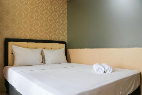a bedroom with a bed with two towels on it at Modern and Nice Studio at Titanium Square Apartment By Travelio in Jakarta