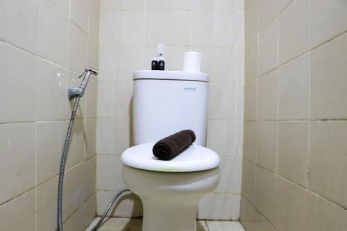 a bathroom with a toilet with a towel on the seat at Modern and Nice Studio at Titanium Square Apartment By Travelio in Jakarta