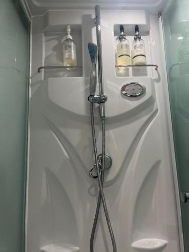 a shower stall with a shower head and a hose at 青島オーベルジュ in Miyazaki