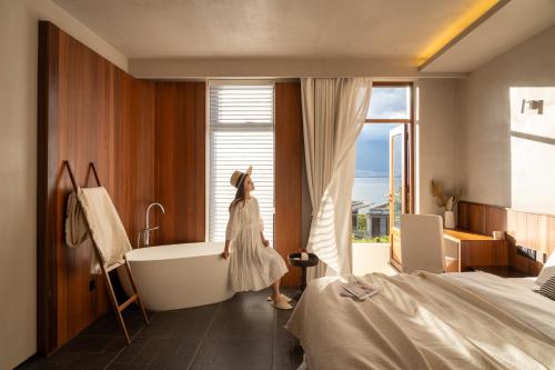 a woman standing in a bathroom with a bath tub at Erhai Seaview Garden Villa &Dali Airport in Dali
