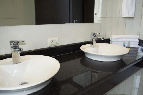 a bathroom with two sinks and a large mirror at Puerto Azul Hotel in Puntarenas