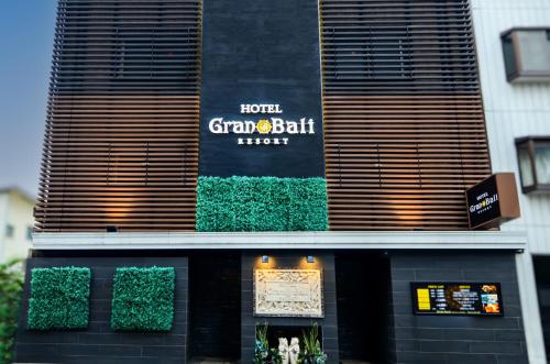 a restaurant with a sign on the side of a building at Hotel Gran Bali Resort in Kawasaki