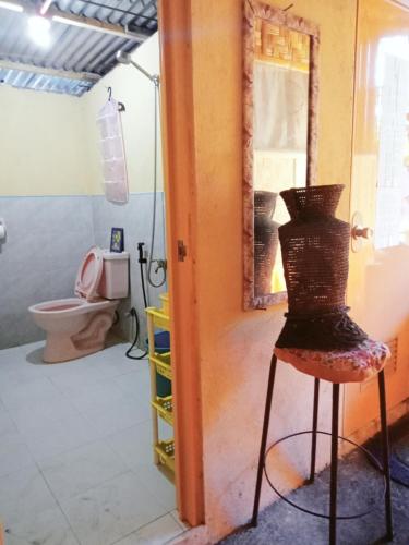 a bathroom with a toilet and a stool in a room at JUNGLE GYM LA UNION Prana fan kubo 2 pax in Rimus