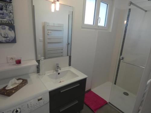 une salle de bain blanche avec un lavabo et une douche dans l'établissement Maison de Vacances Spacieuse, Proche Forêt, 5 Pers., Terrasse & Parking, Notre-Dame-de-Monts - FR-1-540-280, à Notre-Dame-de-Monts
