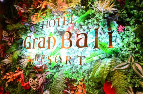 a sign that says hotel grand beach resort with plants at Hotel Gran Bali Resort in Kawasaki