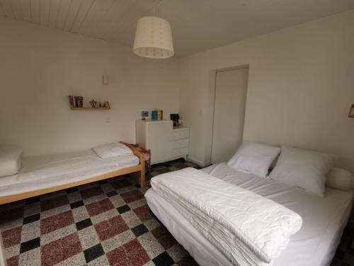- une chambre avec 2 lits et un sol en damier dans l'établissement Maison de vacances à Notre-Dame-de-Monts - 4 pers, proche forêt, terr., animaux OK - FR-1-540-281, à Notre-Dame-de-Monts