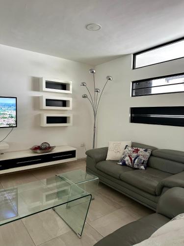 a living room with a couch and a glass table at Casa Romelia in Acatepec