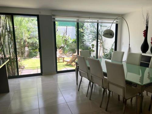 a dining room with a green table and chairs at Casa Romelia in Acatepec