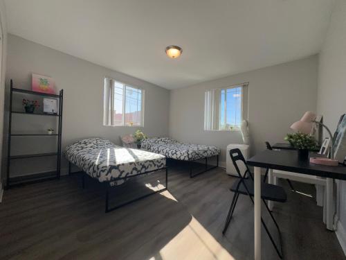 a room with two beds and a desk and a table at Blue Stay near BMO Stadium and USC Private Room in Los Angeles