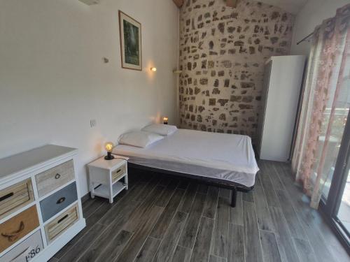 ein Schlafzimmer mit einem Bett und einer Ziegelwand in der Unterkunft Villa 3 pièces climatisée, terrasse, piscine, proche commerces et centre-ville – Sainte-Maxime - FR-1-780-64 in Sainte-Maxime