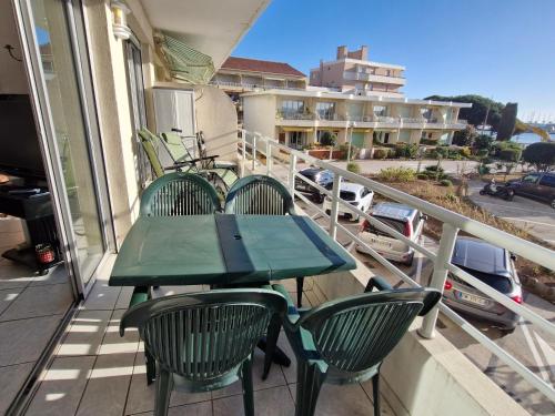 d'une table et de chaises vertes sur un balcon avec vue. dans l'établissement Appartement 2 pièces climatisé centre Sainte-Maxime avec parking et balcon - FR-1-780-70, à Sainte-Maxime