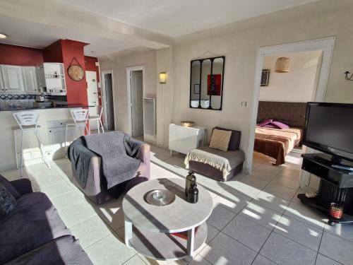 un salon avec un canapé et une table et une cuisine dans l'établissement Appartement 2 pièces climatisé centre Sainte-Maxime avec parking et balcon - FR-1-780-70, à Sainte-Maxime