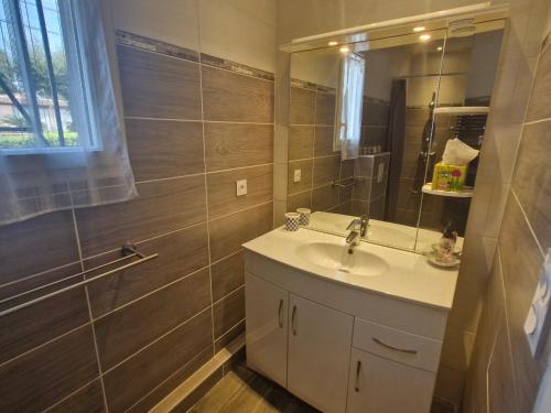 ein Badezimmer mit Waschbecken und Spiegel in der Unterkunft Villa 3 pièces climatisée, terrasse, piscine, proche commerces et centre-ville – Sainte-Maxime - FR-1-780-64 in Sainte-Maxime