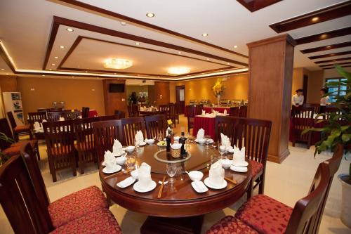 a dining room with a wooden table and chairs at Kenny Hotel Ha Long in Ha Long