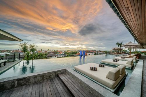 a pool with couches and chairs on top of a building at TUI BLUE Berawa Hotel and Villas in Canggu