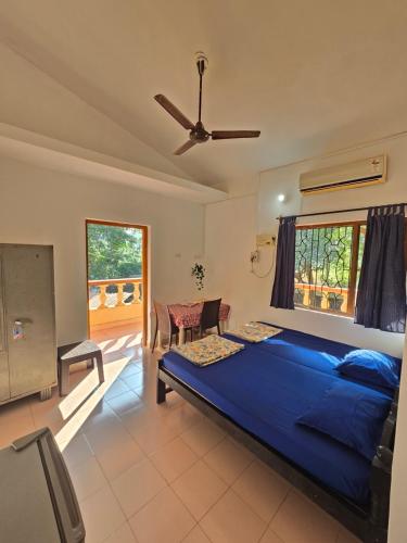 Un dormitorio con una gran cama azul y una ventana en Georgedale Guest House, en Calangute