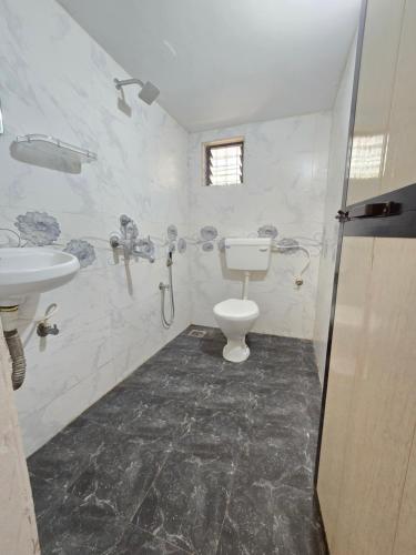 un baño con inodoro y lavabo en Georgedale Guest House, en Calangute