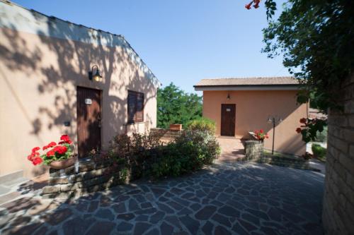 a building with a door and flowers in a courtyard at Agriturismo La Molara in Sessa Aurunca