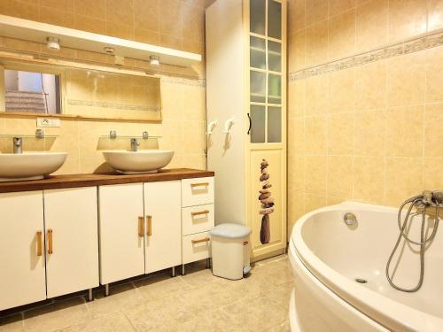 une salle de bain avec deux lavabos et une baignoire dans l'établissement Appartement 3 pièces avec jardin, proche du port et du centre, idéal pour vacances à Banyuls-sur-Mer - FR-1-309-465, à Banyuls-sur-Mer