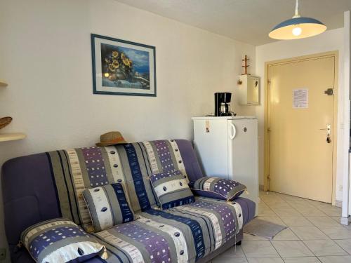 - un salon avec un canapé et un réfrigérateur dans l'établissement **Gruissan : T2 cosy avec piscine, parking privé, proche plage et commerces** - FR-1-796-8, à Gruissan