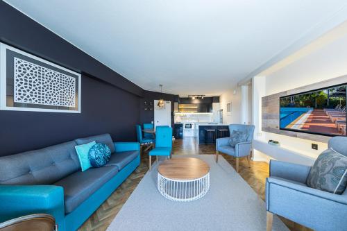 a living room with a blue couch and a table at Accor Vacation Club at Pacific Bay in Coffs Harbour