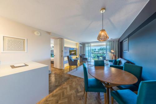 a living room with a table and blue chairs at Accor Vacation Club at Pacific Bay in Coffs Harbour
