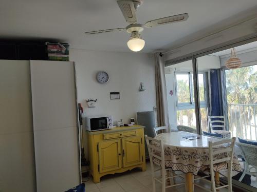Il comprend une cuisine équipée d'une table et d'un réfrigérateur jaune. dans l'établissement Studio cosy avec parking sécurisé à 50m de la Plage du Grazel - FR-1-796-47, à Gruissan