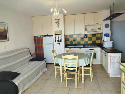 une cuisine avec une table et des chaises dans une pièce dans l'établissement T2 Alcove à Gruissan, Plage, Piscine & Parking - FR-1-796-41, à Gruissan