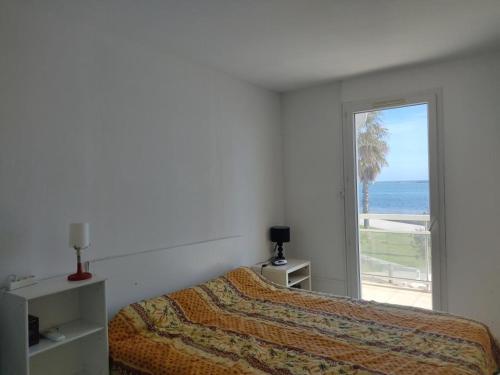 une chambre avec un lit et une vue sur l'océan dans l'établissement Gruissan - Villa T4 - Clim, WiFi, Parking, Plage 50m - 6 pers - FR-1-796-55, à Gruissan