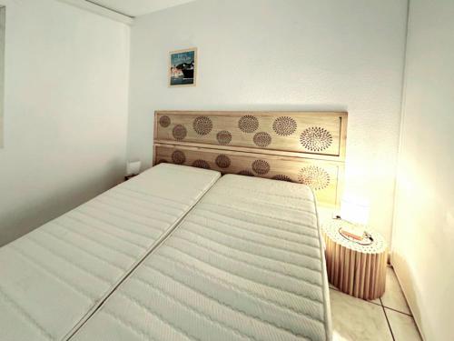 une petite chambre avec un lit et une table dans l'établissement Canet-en-Roussillon T2 Moderne - Climatisation - Parking privé - Plage à 2 pas! - FR-1-794-155, à Canet